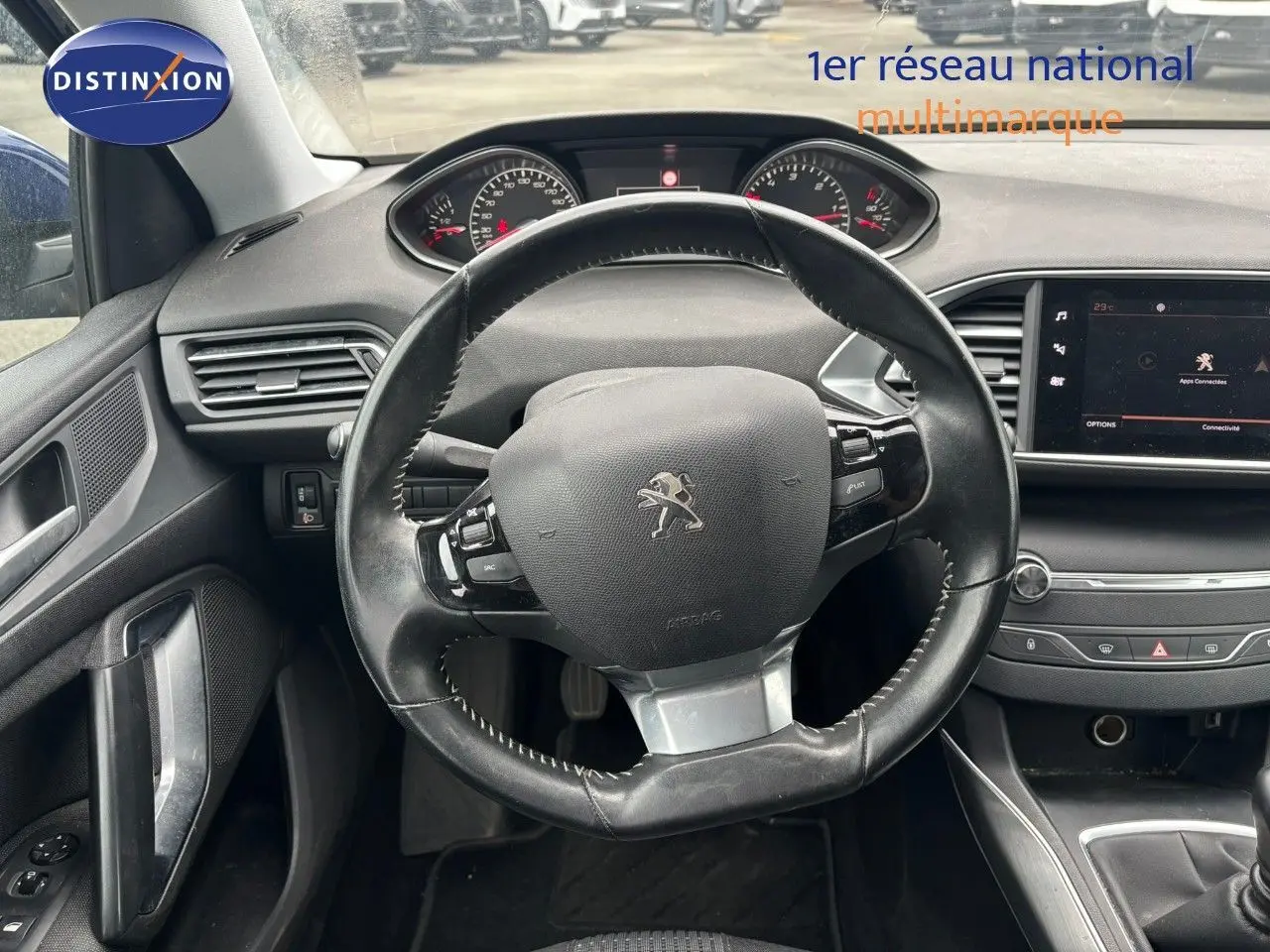 Vue intérieure centrée sur le volant cuir noir et le tableau de bord de la Peugeot 308 Bleu Magnetic de 2020.