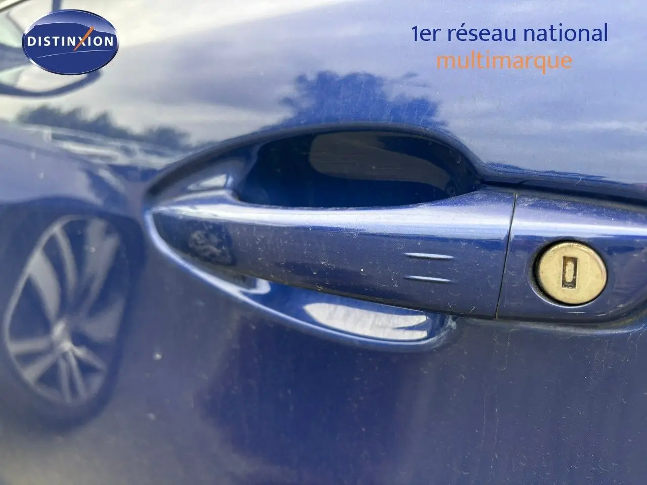 Poignée de porte côté gauche bleu Magnetic d'une Peugeot 308 2020 avec serrure visible et reflet de roue.