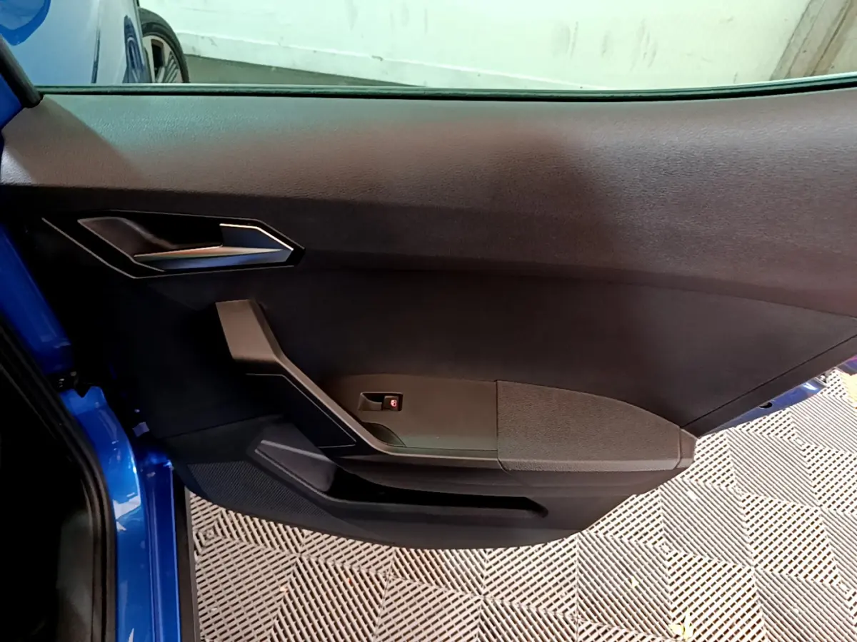 Vue rapprochée de la porte avant gauche bleu vif du SEAT Arona 2022 avec garniture noire et poignée argentée.