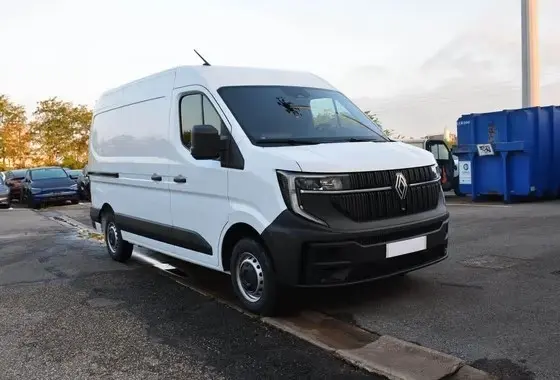 Renault Master blanc en vue 3/4 avant droit, avec calandre noire et feux LED, stationné sur un parking extérieur.