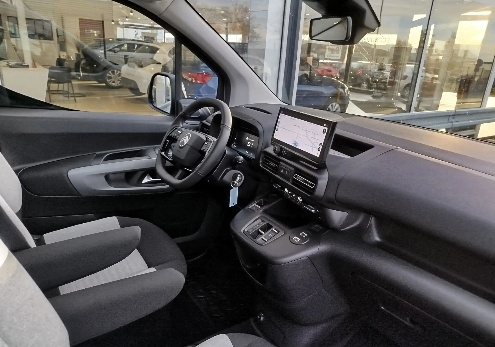Vue intérieure côté conducteur du Citroën Berlingo 2026 gris acier, avec tableau de bord moderne et écran tactile central.