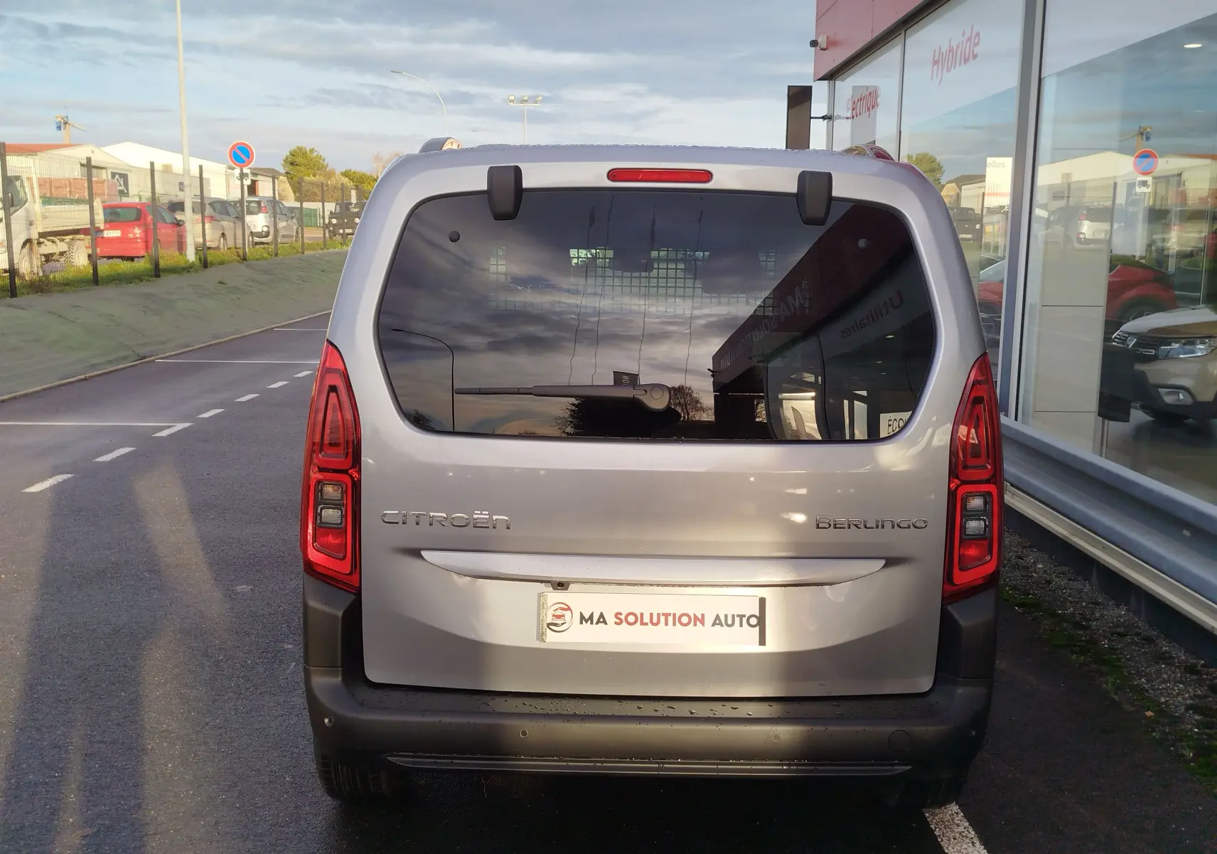 Vue arrière d'un Citroën Berlingo gris acier 2026 avec vitres teintées et feux arrière verticaux rouges.