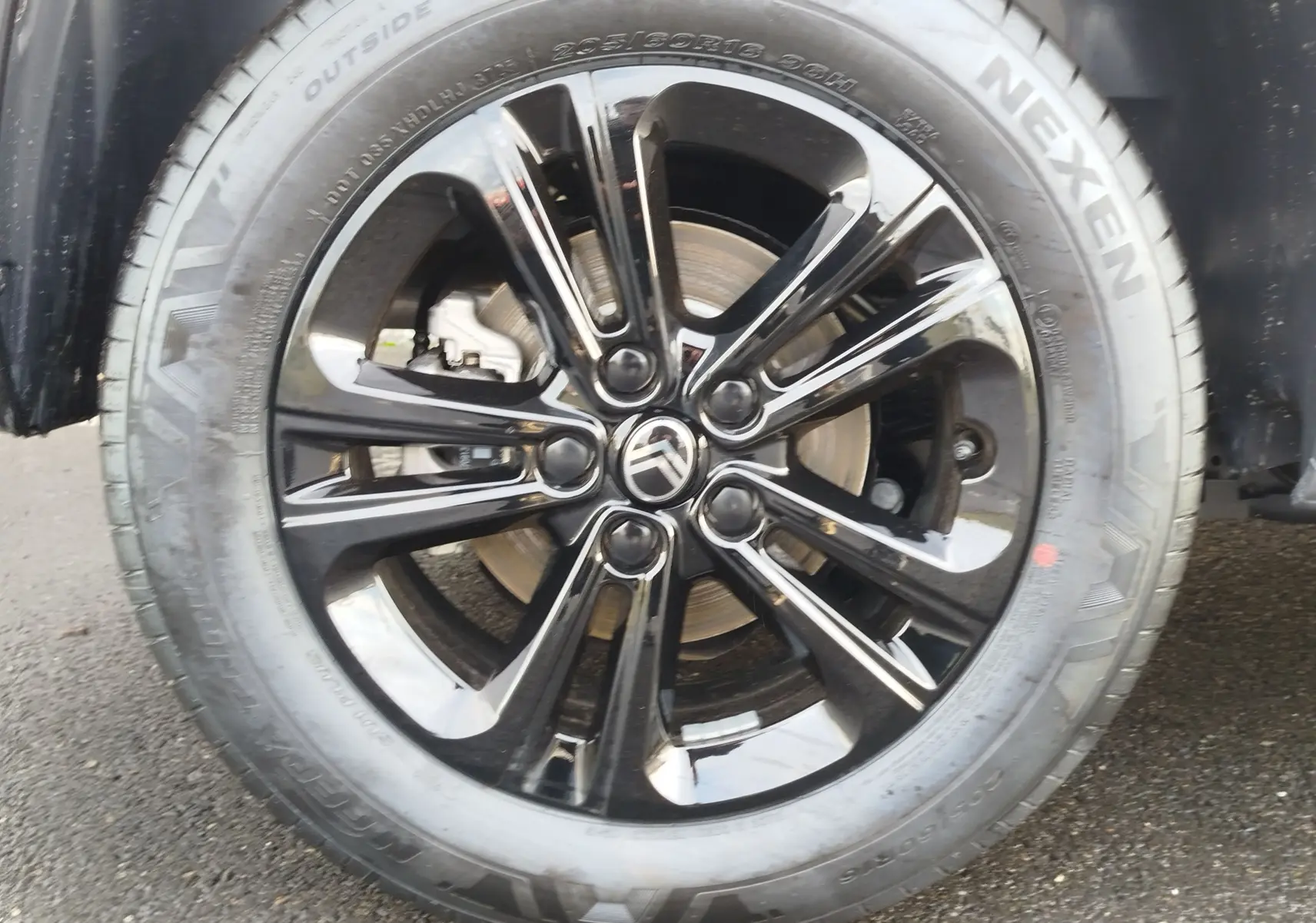 Gros plan sur la roue avant droite du Citroën Berlingo 2026, jante alliage noire brillante avec logo Citroën central.