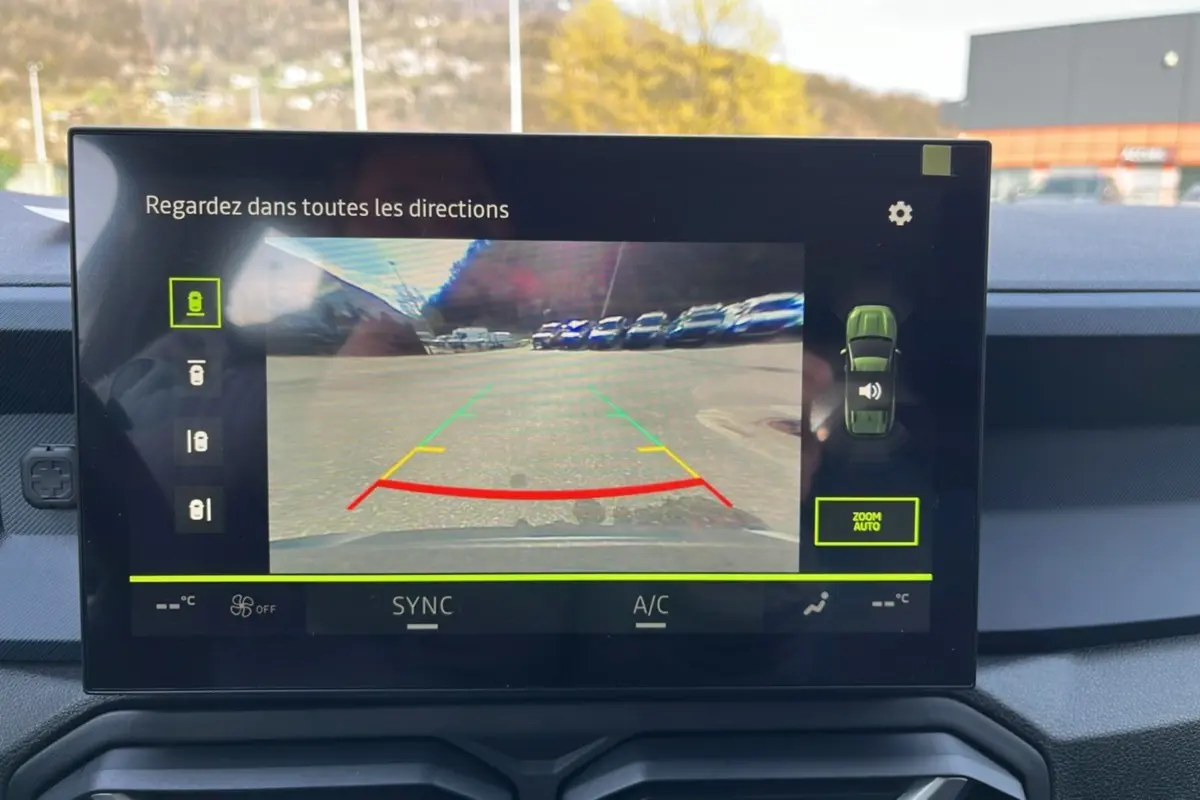 Écran tactile intérieur montrant la caméra multiview arrière du Dacia Bigster gris schiste en stationnement.