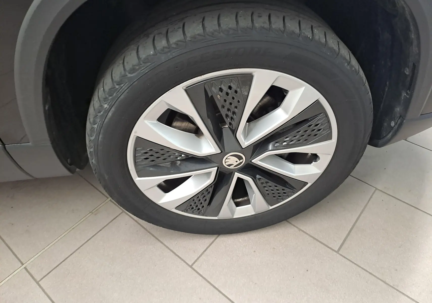 Gros plan sur la roue avant gauche du Skoda Karoq noir Magic Nacré avec jante alliage au design moderne.