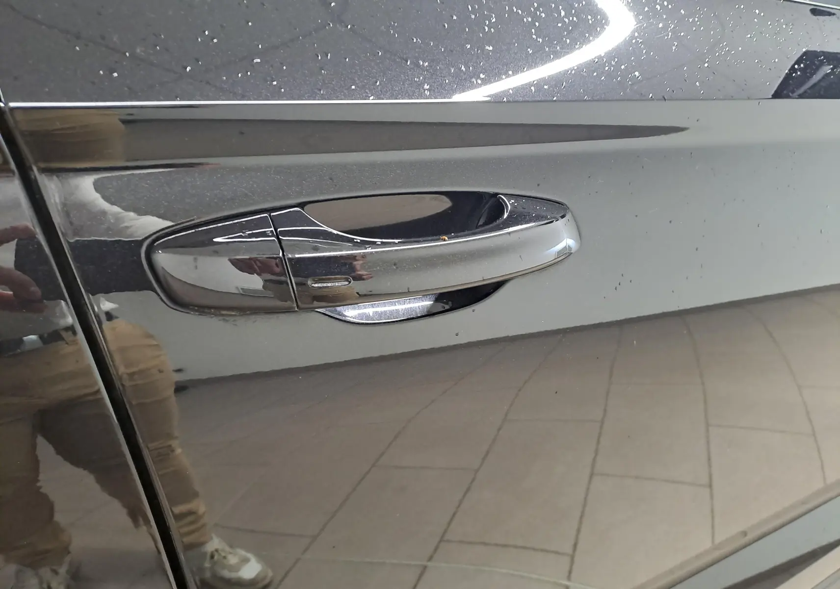 Poignée de porte côté gauche du Skoda Karoq noir Magic Nacré 2023 avec finition brillante et capteur intégré.