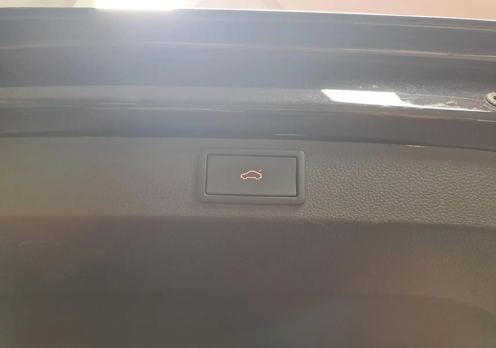 Bouton d'ouverture électrique du coffre sur la partie intérieure du hayon noir nacré d'un Skoda Karoq 2023.