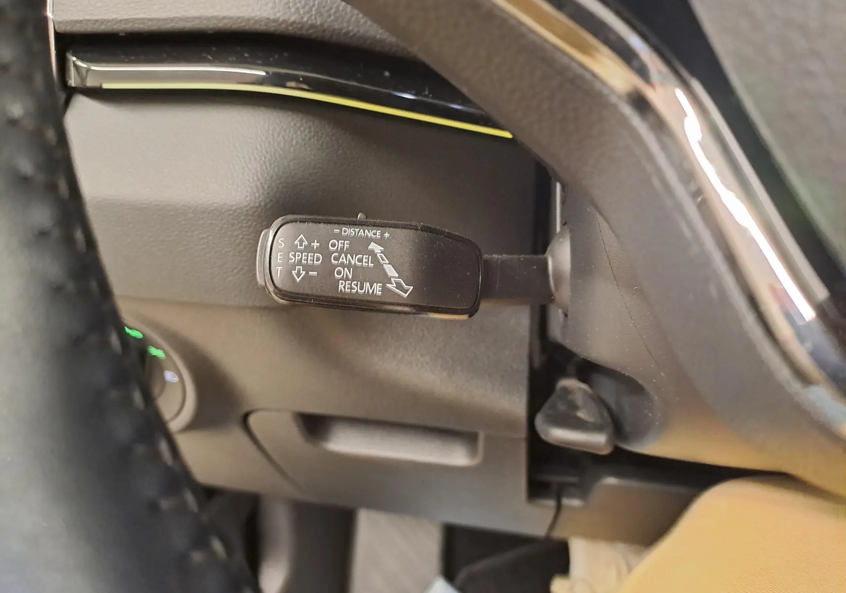 Gros plan sur la commande de régulateur de vitesse au volant d’un Skoda Karoq noir Magic Nacré, intérieur cuir.