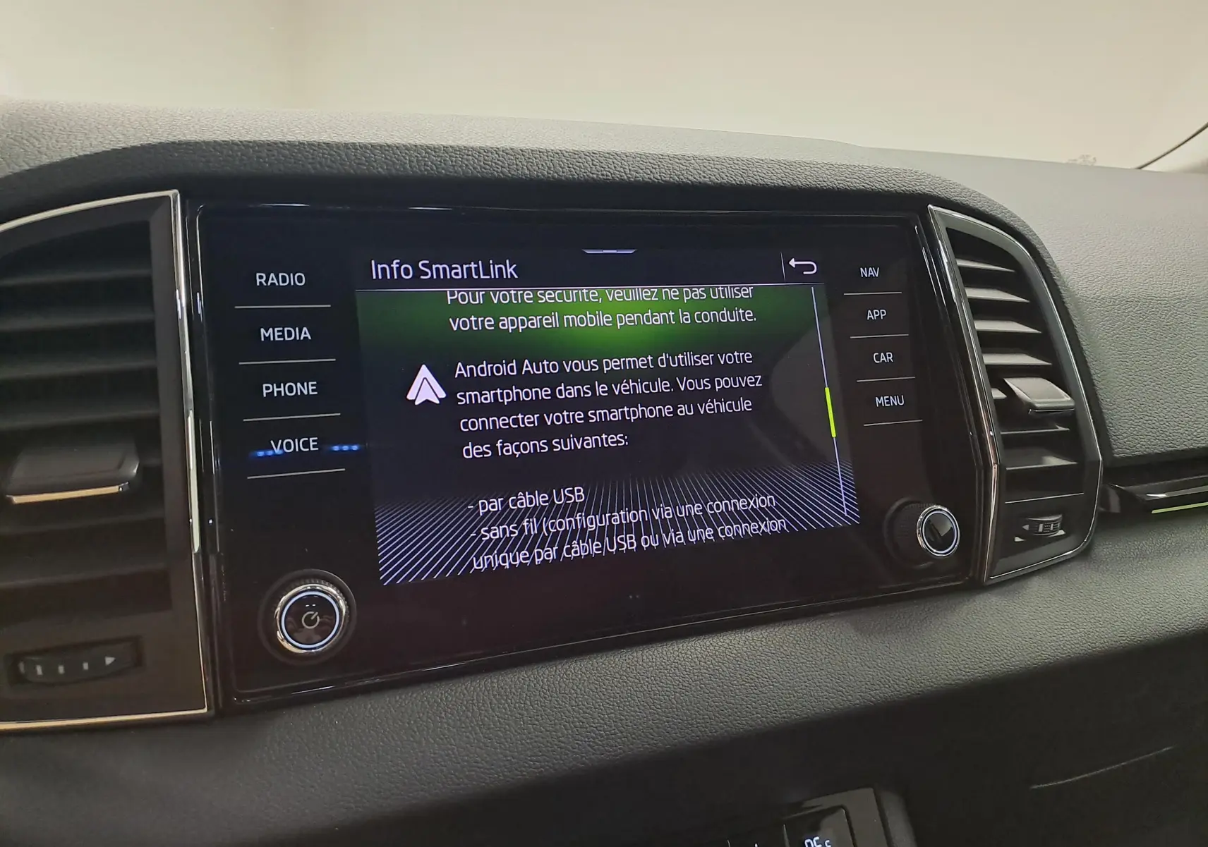 Gros plan sur l'écran tactile central du Skoda Karoq noir Magic Nacré 2023, affichant l'interface SmartLink.