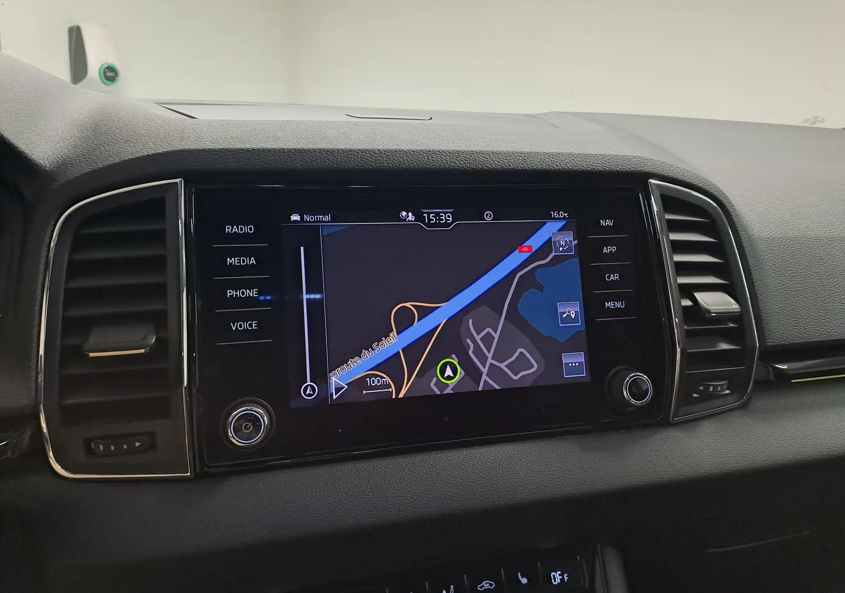 Vue rapprochée de l’écran tactile central du Skoda Karoq 2023, affichant la navigation GPS, entouré de commandes noires.