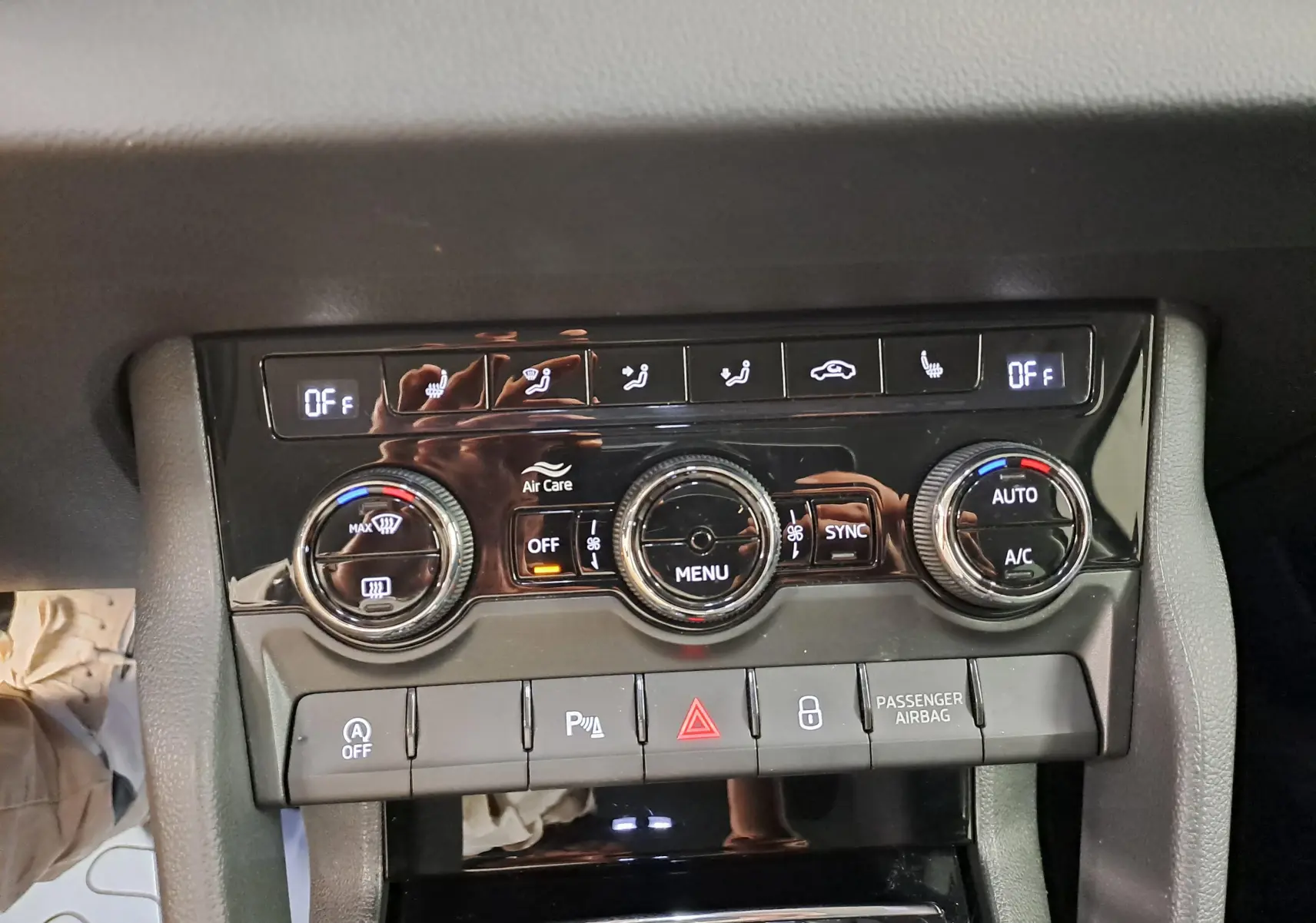 Vue rapprochée de la console centrale du Skoda Karoq 2023, boutons de climatisation et réglages visibles.