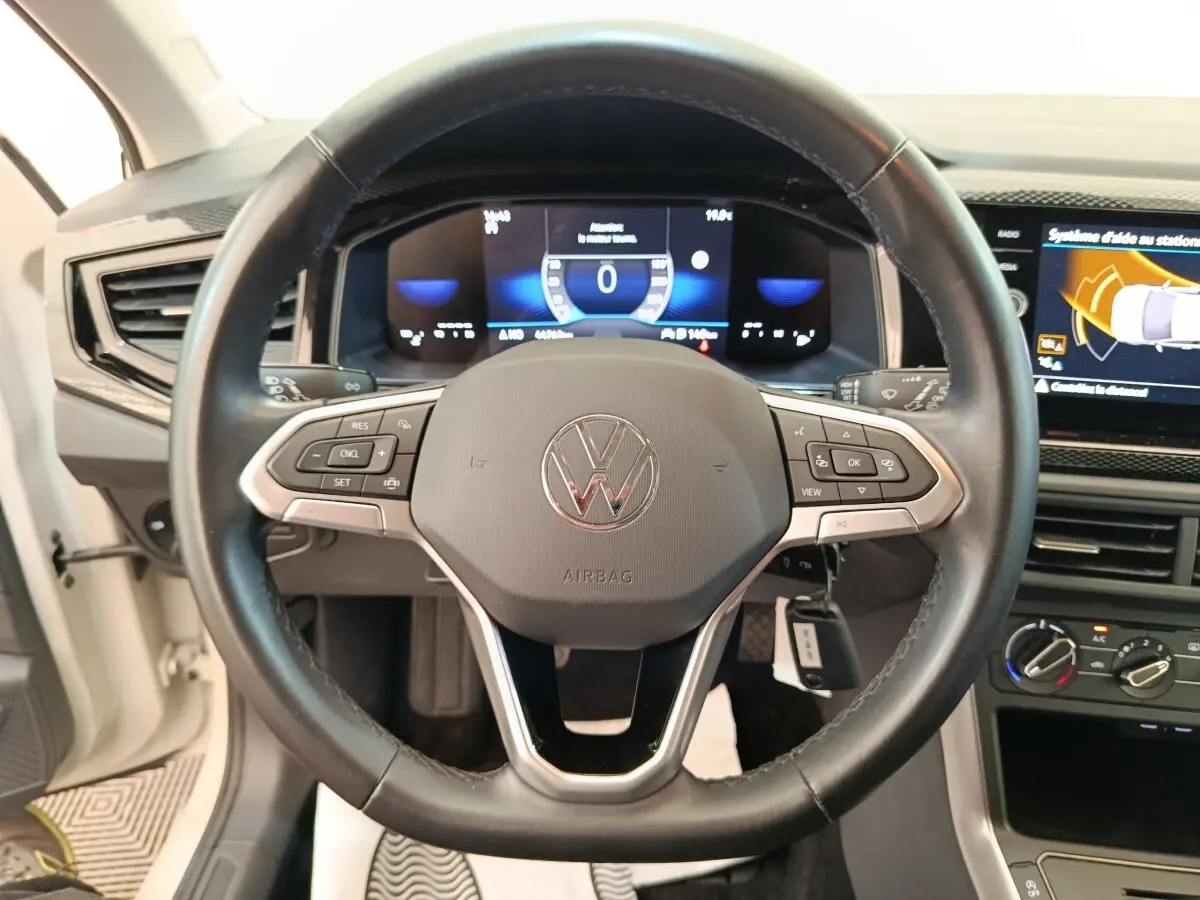 Vue intérieure centrée sur le volant cuir et alu multifonctions de la Volkswagen Polo 2023 avec tableau de bord digital.