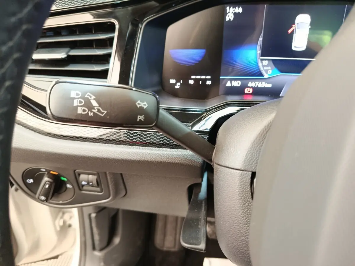 Détail intérieur du tableau de bord côté gauche de la Volkswagen Polo 2023 avec commandes de phares et levier de clignotant.