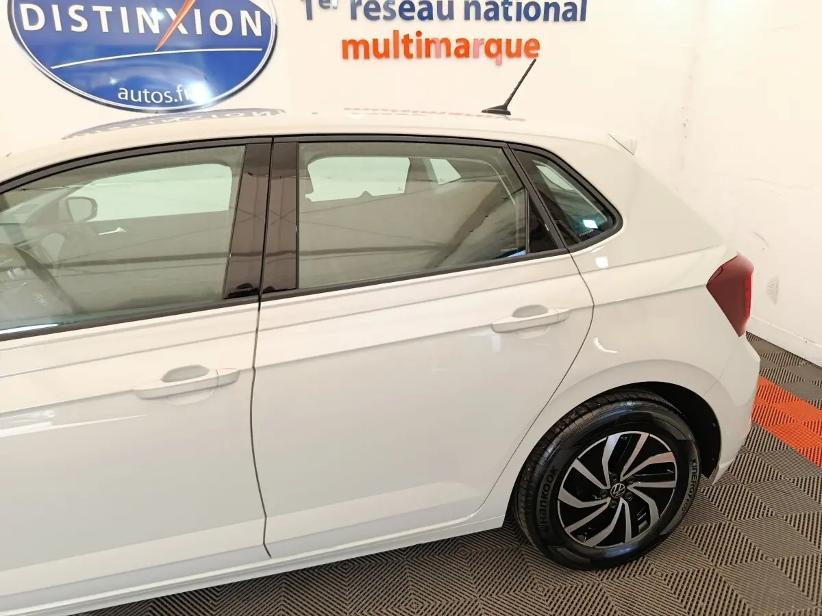 Vue côté droit arrière d'une Volkswagen Polo gris clair avec jantes alliage et vitres teintées.