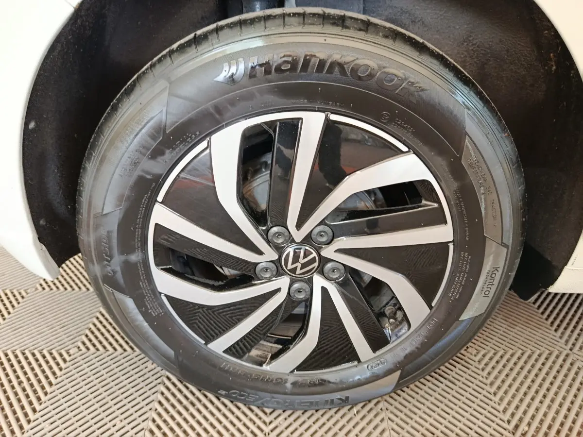 Gros plan sur la jante alliage bicolore noire et argentée d'une Volkswagen Polo gris clair, côté roue avant.