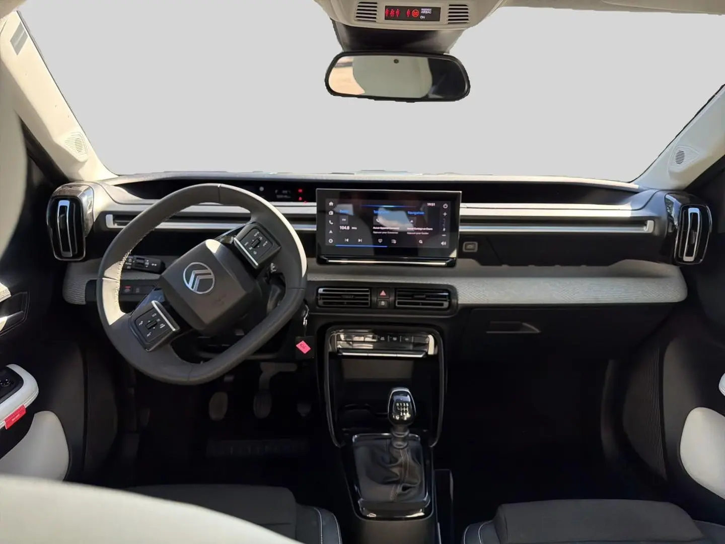 Vue intérieure avant de la Citroën C3 1.2 turbo 100 essence 2025, volant multifonction et écran tactile central.