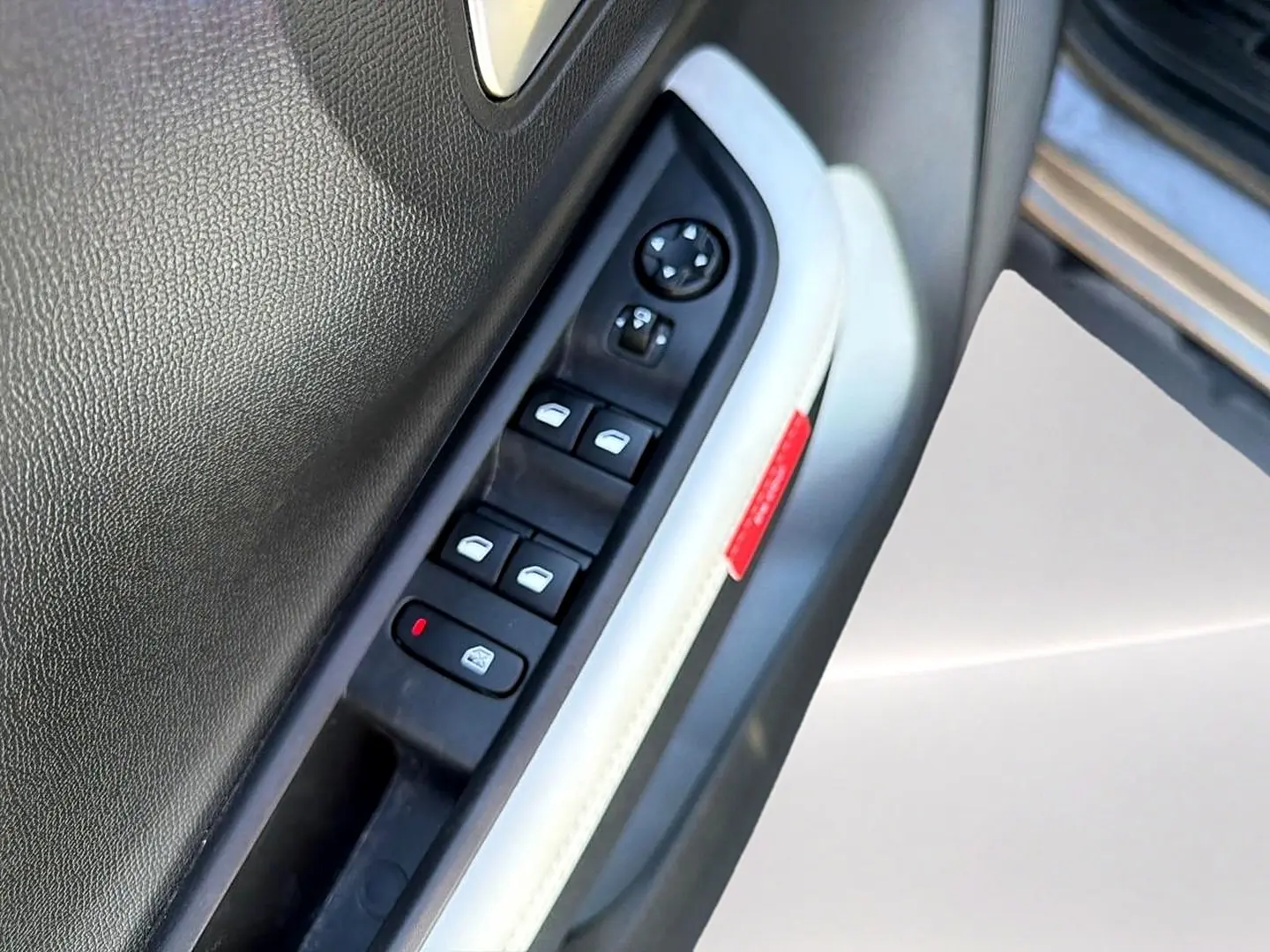 Gros plan sur la commande des vitres électriques côté conducteur de la Citroën C3 2025, garniture intérieure gris clair.