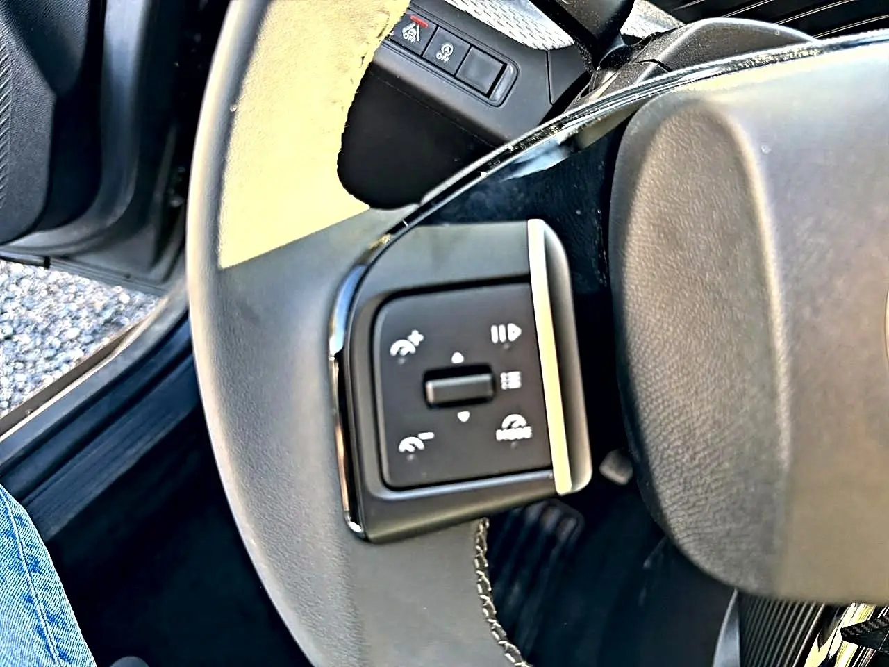 Gros plan sur les commandes audio et téléphone au volant d’une Citroën C3 gris mercure, intérieur côté conducteur.