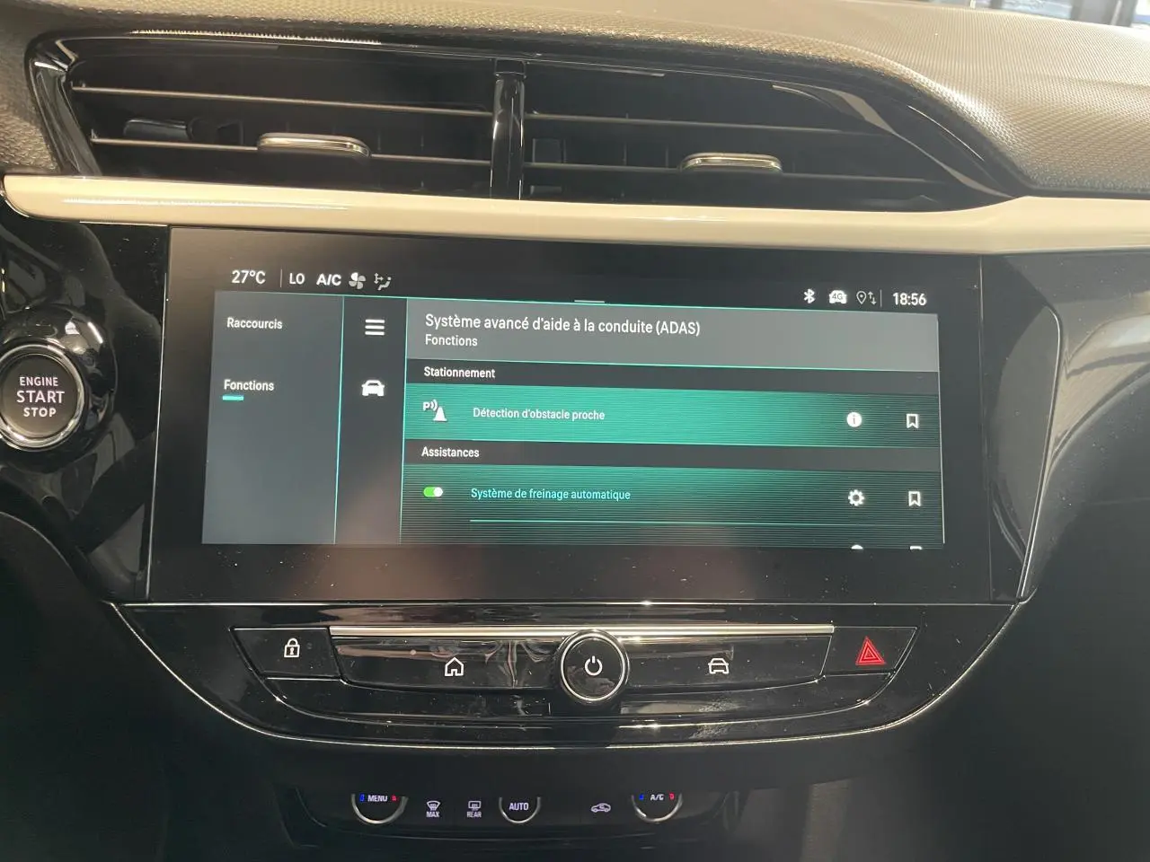 Vue rapprochée de l’écran tactile central noir de l’Opel Corsa gris, affichant les aides à la conduite avancées.