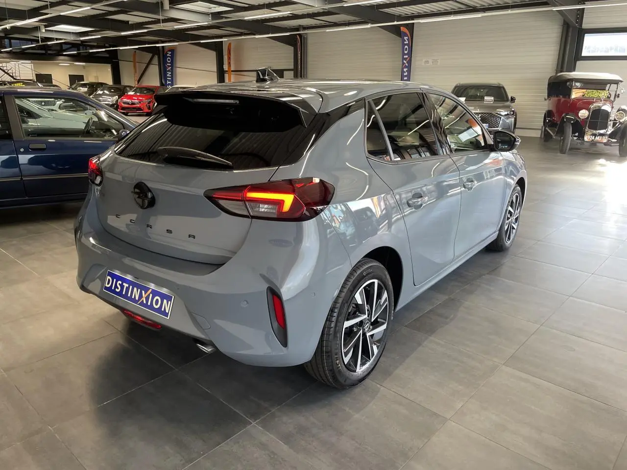 Vue 3/4 arrière droite d'une Opel Corsa gris Grafik avec jantes alliage diamantées en showroom.