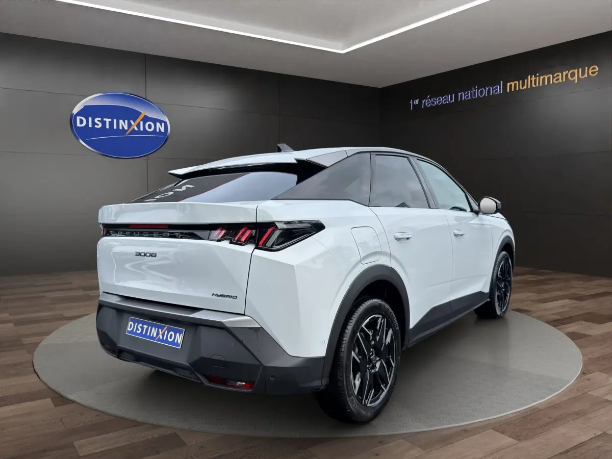 Vue 3/4 arrière droite du Peugeot 3008 blanc hybride 2025 avec feux LED et jantes noires distinctives.