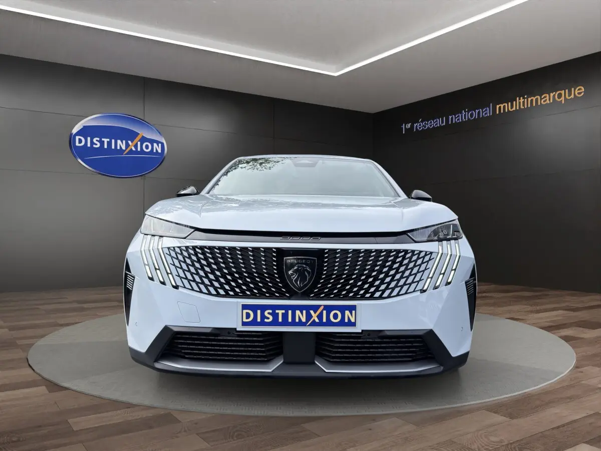 Vue frontale du Peugeot 3008 blanc 2025 avec calandre noire à motif géométrique et phares LED distinctifs.