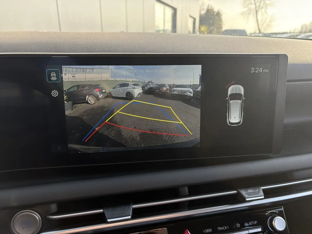 Écran tactile intérieur montrant la caméra de recul du Hyundai Tucson Cypress Green avec lignes de guidage colorées.