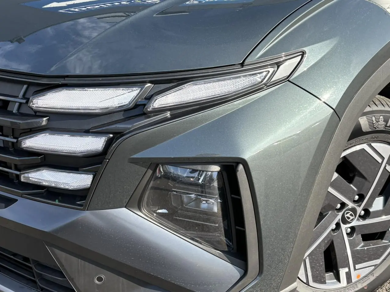 Gros plan sur l'avant droit du Hyundai Tucson Cypress Green, mettant en valeur ses phares LED et jante alliage 17 pouces.