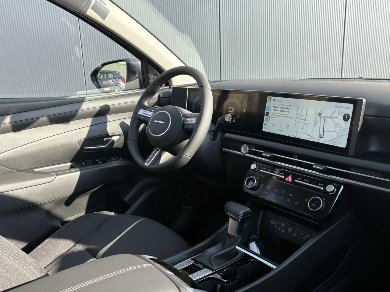 Intérieur du Hyundai Tucson 2025 vu côté conducteur, tableau de bord moderne avec écran tactile panoramique.