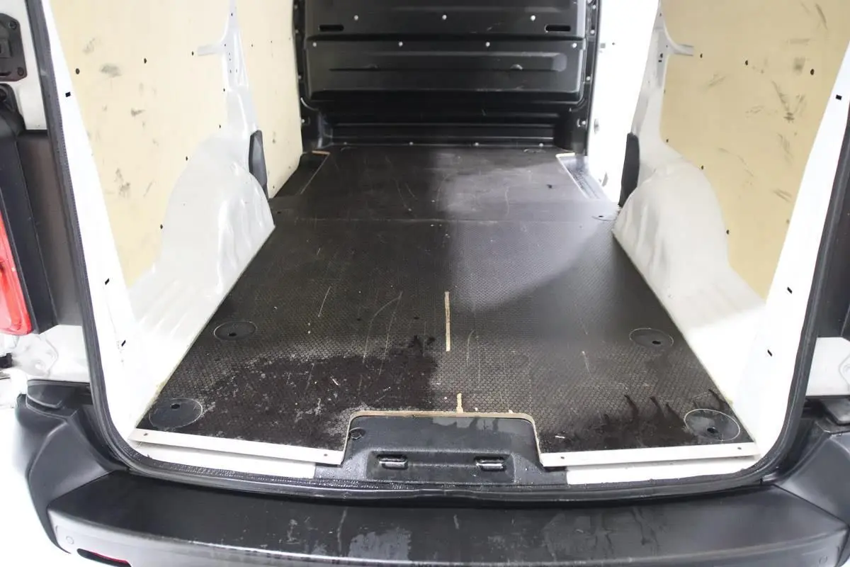 Vue arrière du fourgon blanc Citroën Jumpy XL 2019 montrant l'espace de chargement avec revêtement bois et attelage.