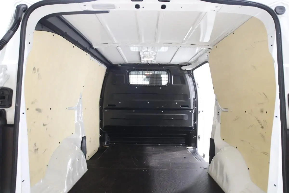 Intérieur du fourgon blanc Citroën Jumpy XL 2019, vue de la zone de chargement avec habillage bois et cloison métallique noire.