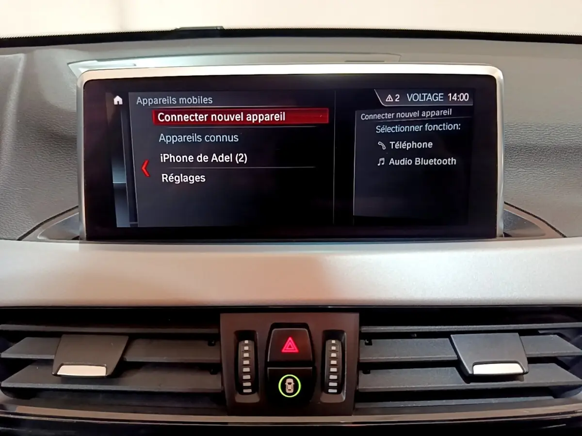 Écran tactile central du tableau de bord d'une BMW X1 2020 affichant le menu Bluetooth en intérieur noir et gris.