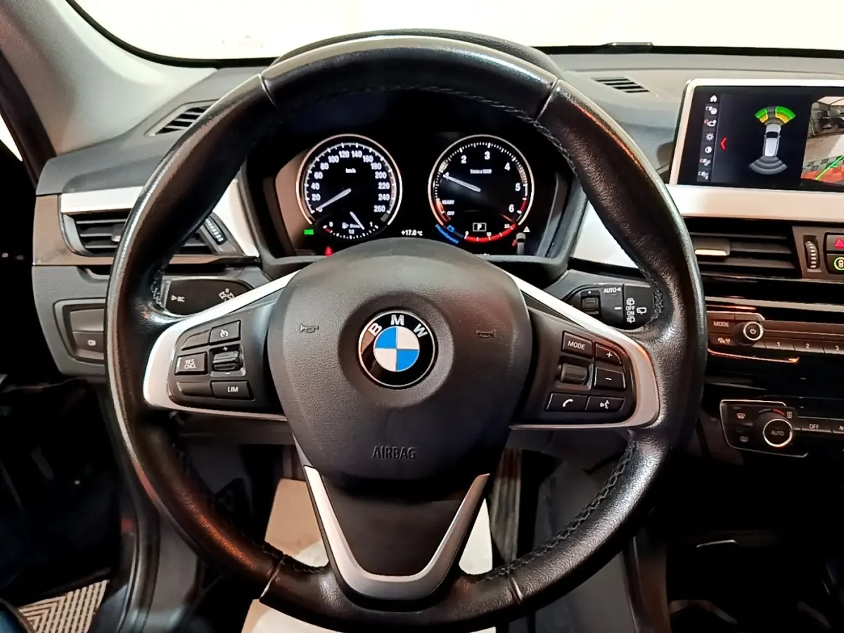 Vue rapprochée du volant cuir noir de la BMW X1 2020 avec tableau de bord et écran tactile multifonctions.