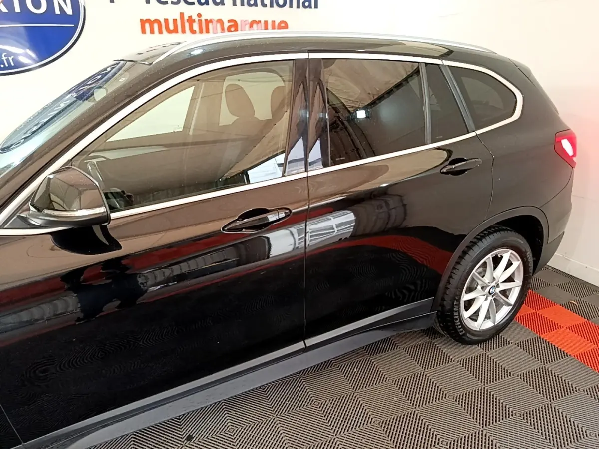 Vue latérale côté gauche d'un BMW X1 noir 2020 avec jantes alliage et rétroviseur chromé électrique.