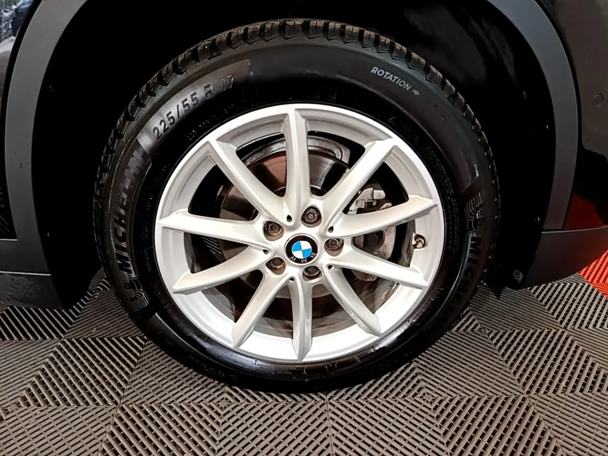 Gros plan sur la roue avant droite d’un BMW X1 noir avec jante alliage argent et pneu Michelin.