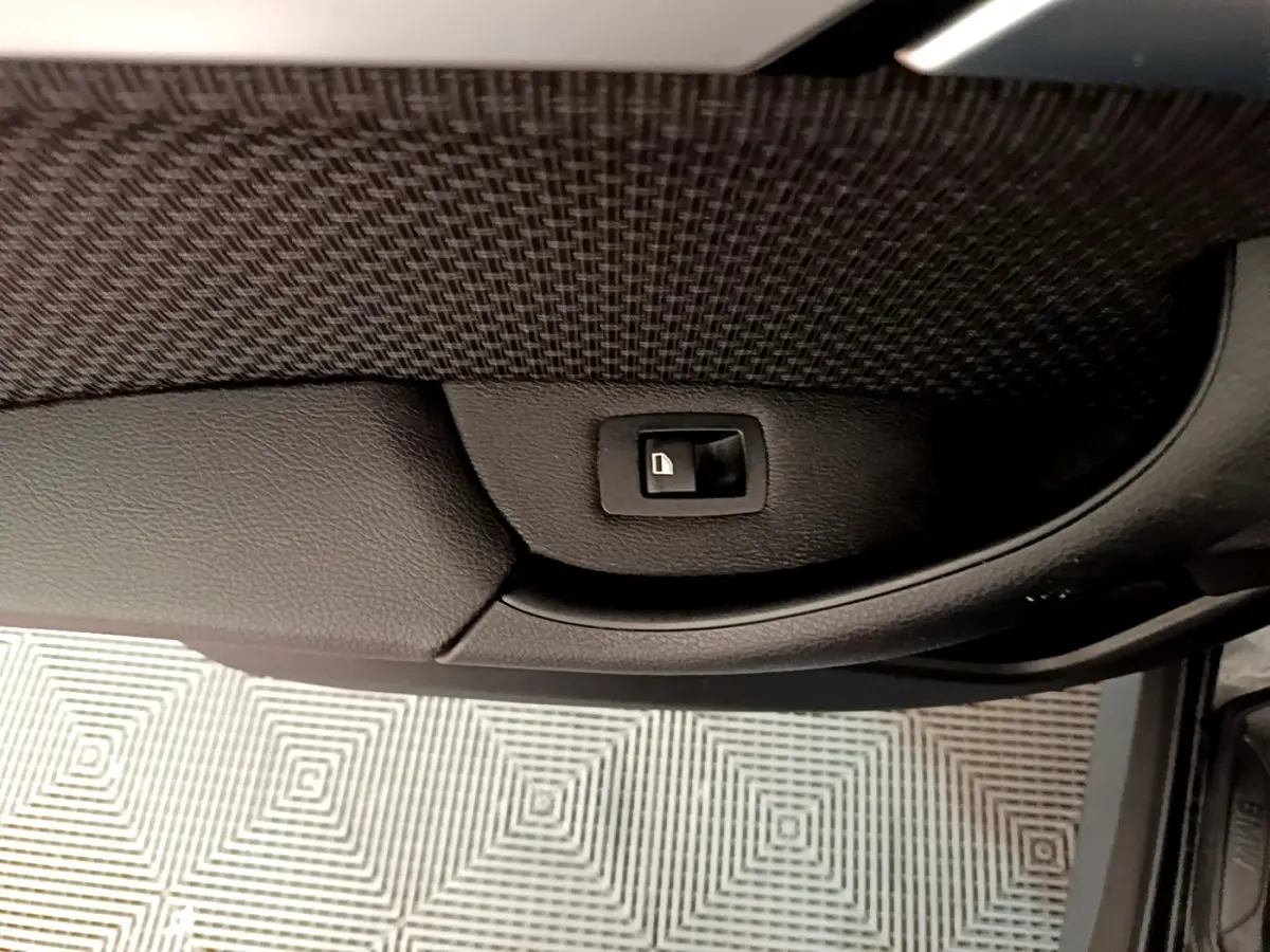 Bouton de verrouillage de porte intégré dans la garniture intérieure noire de la portière côté conducteur du BMW X1 noir 2020.