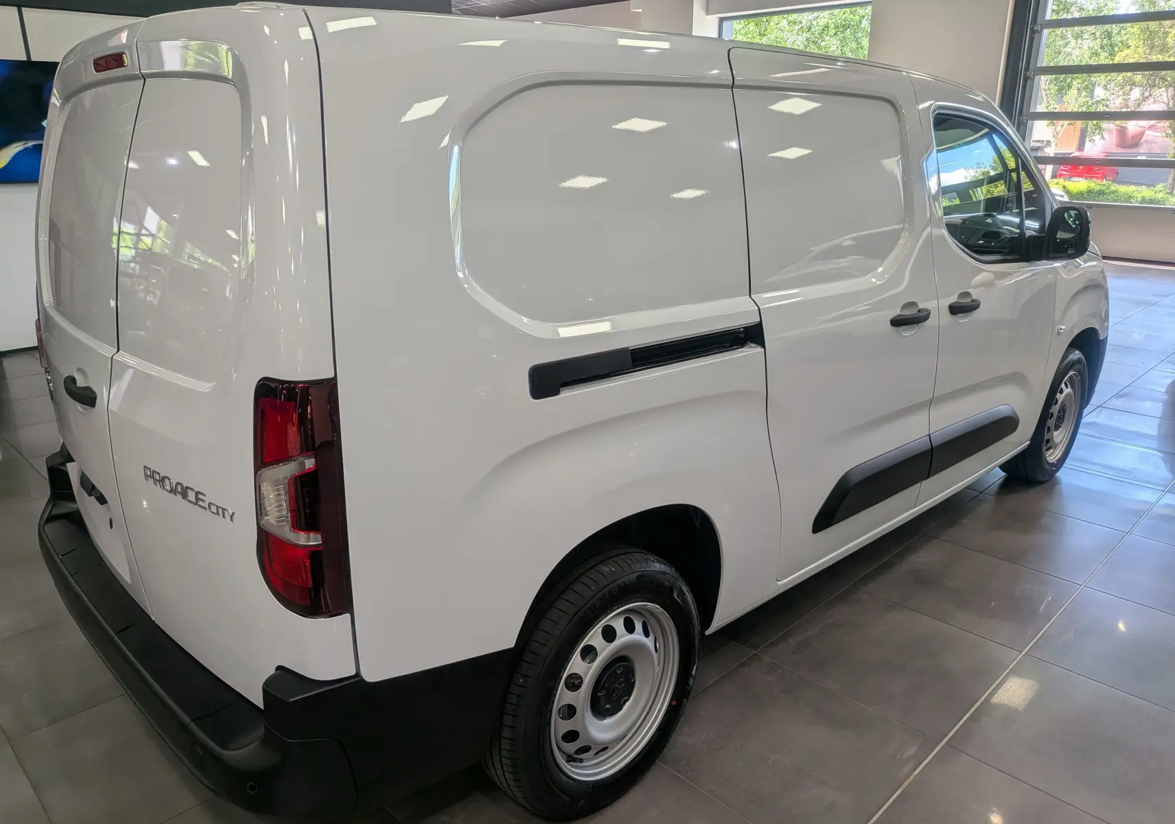 Vue 3/4 arrière droite d’un Toyota Proace City Long blanc Glacier, fourgon utilitaire avec portes latérales et arrière pleines.