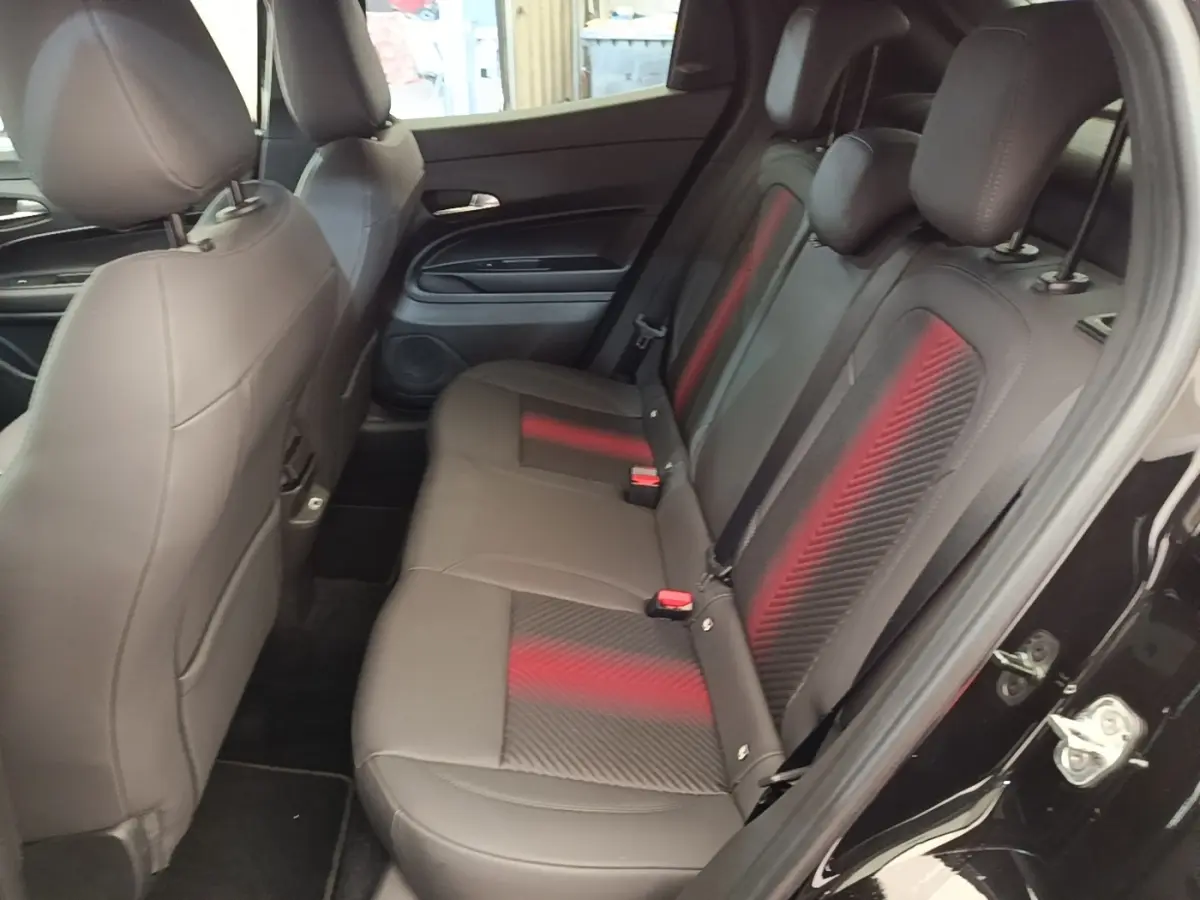 Vue côté droit des sièges arrière noirs avec inserts rouges de l'Alfa Romeo Junior 1.2 Ibrida 2024.