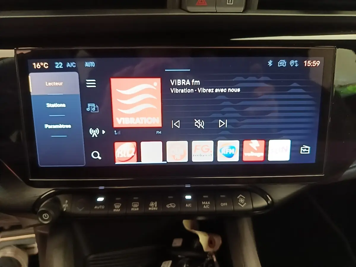 Écran tactile central de 10,25 pouces affichant la radio, dans l’habitacle noir de l’Alfa Romeo Junior 1.2 Ibrida 2024.