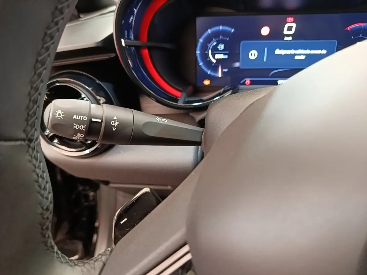 Gros plan sur le combiné d'instruments numérique avec éclairage rouge et levier de commande des phares sur l'Alfa Romeo Junior 2024.