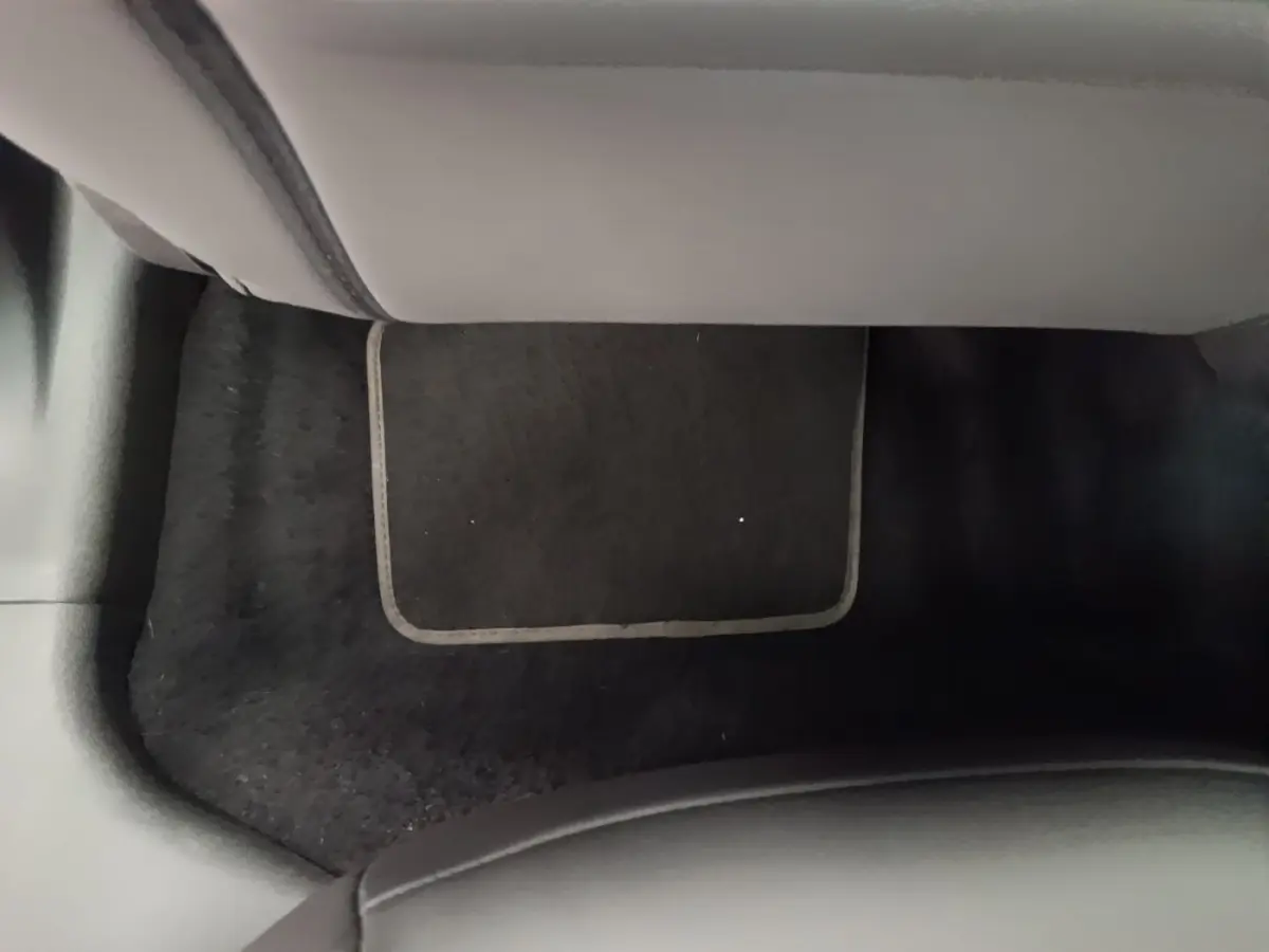 Vue intérieure du plancher avant droit avec tapis noir dans l'Alfa Romeo Junior 1.2 Ibrida 2024 noire.