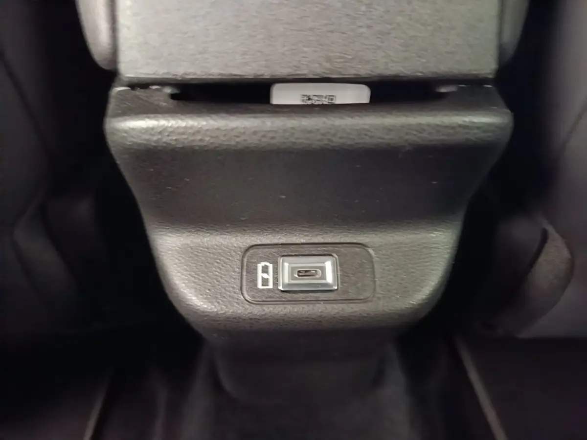 Gros plan sur la prise USB-C située à l'arrière de la console centrale de l'Alfa Romeo Junior noire 2024.