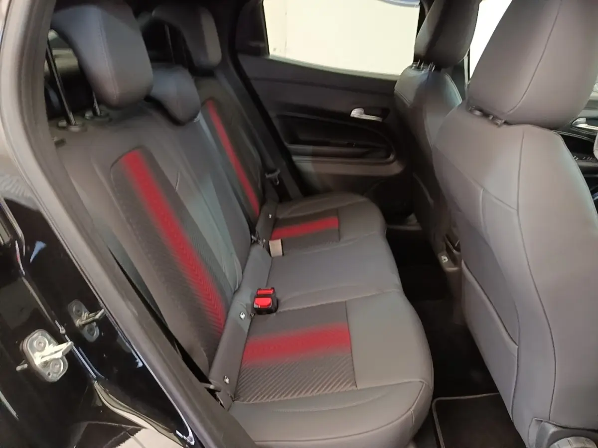 Vue intérieure côté gauche montrant la banquette arrière noire avec inserts rouges de l'Alfa Romeo Junior 2024.
