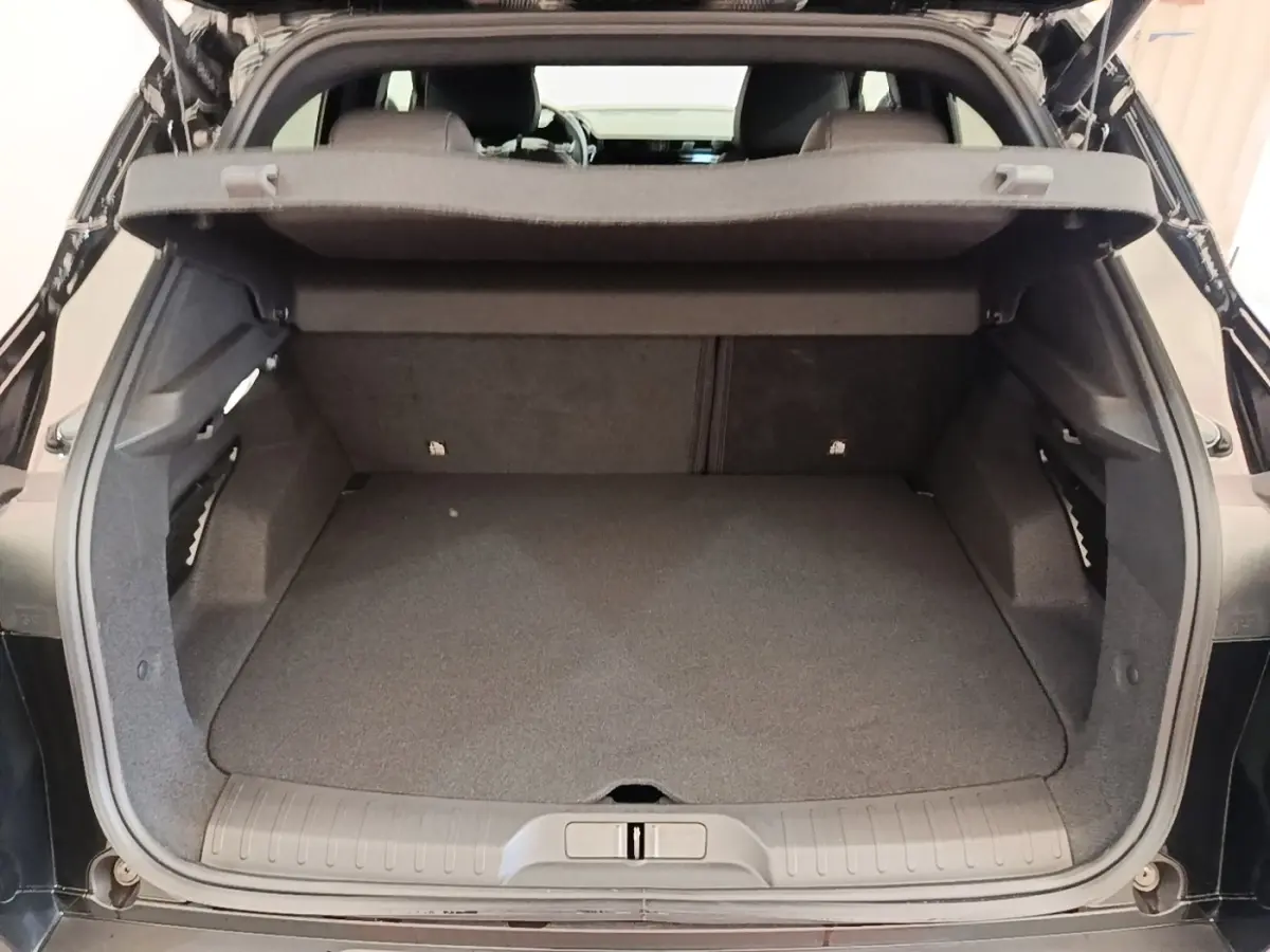 Coffre ouvert d’une Alfa Romeo Junior 1.2 hybride noire, vue arrière montrant l’espace de chargement vide.