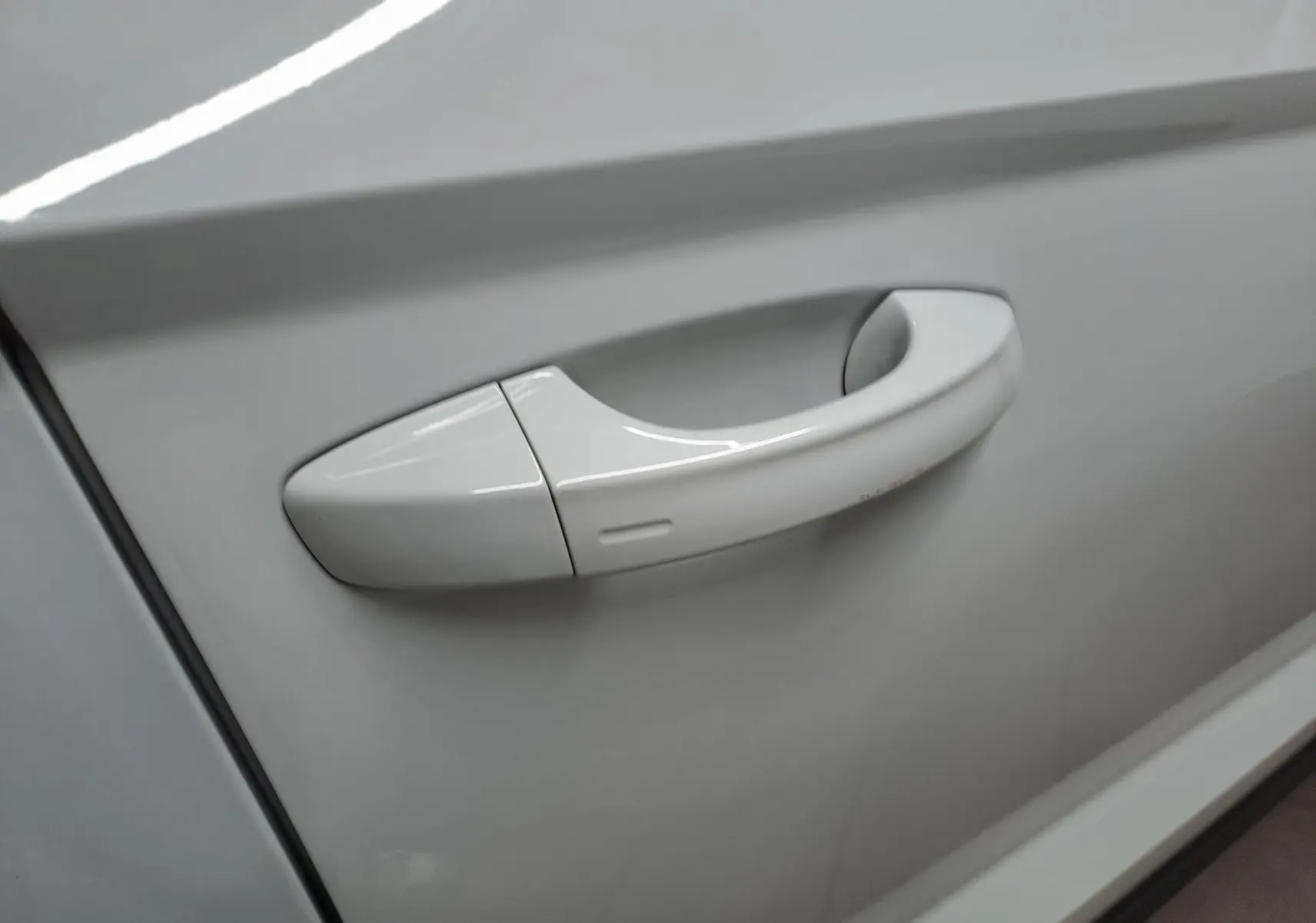 Poignée de porte blanche lune en gros plan sur la portière d'un Skoda Karoq 2025, version 1.5 TSI 150 DSG7 Selection.