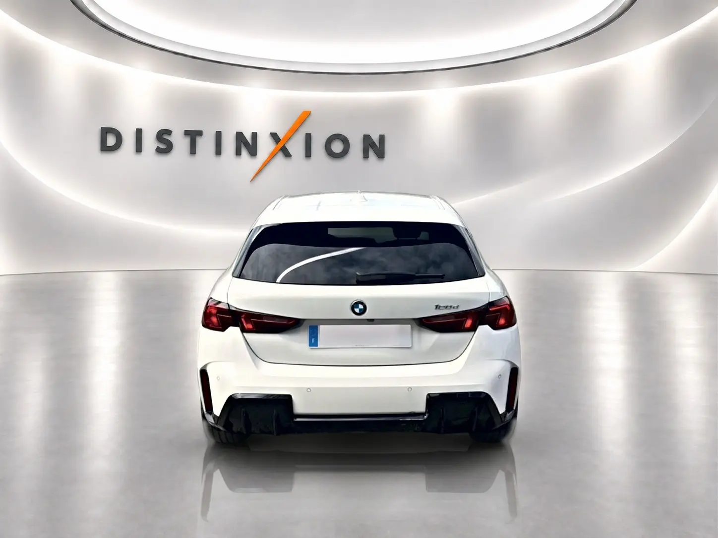 Vue arrière d'une BMW Série 1 blanche pure (120da M Sport) dans un showroom lumineux avec logo Distinxion.