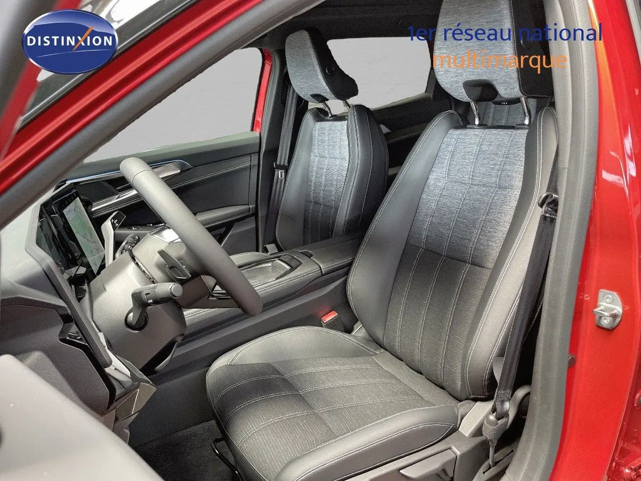 Vue intérieure côté conducteur du Renault Austral 2025 rouge passion, sièges en cuir noir et tissu gris clair.