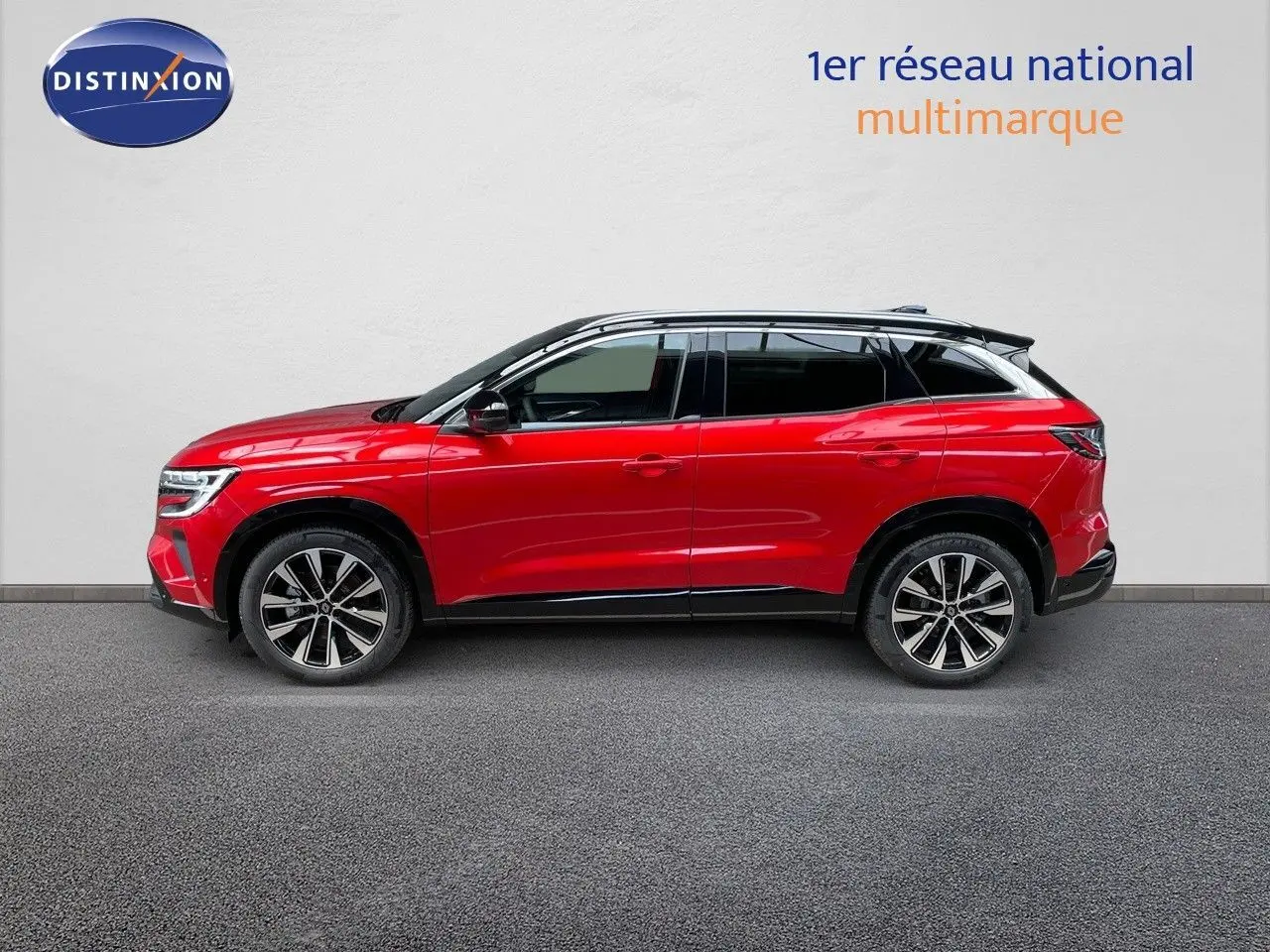 Profil droit du Renault Austral 2025 rouge passion avec toit noir, soulignant ses jantes alliage et lignes modernes.