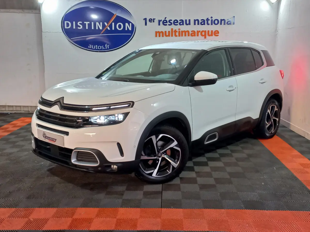 Citroën C5 Aircross blanc en 3/4 avant droit, avec jantes alliage et signature lumineuse LED distinctive.