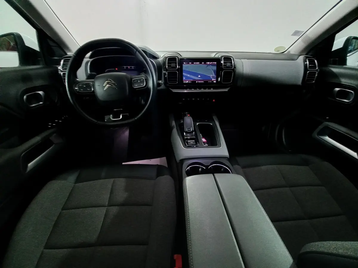 Intérieur noir du Citroën C5 Aircross 2020 vu de face, avec tableau de bord et écran tactile central allumé.